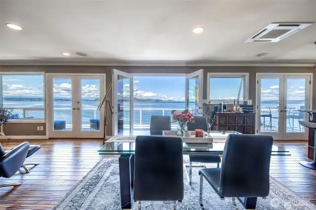 On a clear day, the water sparkles as it catches the light, dotted with ferries, ships, or the occasional paddleboarder. Evergreen-lined shores curve in the distance, and on the horizon the Olympic mountains rise like a watercolor painting. This is the view that anchors the home in nature, serenity, and beauty.