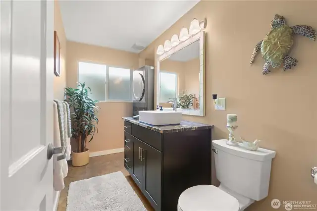 The lower level half bath doubles as the laundry area with the modern stackable washer and dryer unit tucked nicely in the back. Perfect privacy for any guest staying in the lower level bedroom with the Murphy bed.