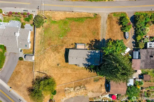 2 lots goes to the driveway on the right in this photo neighbor is parking on this property there is a letter that he will not claim adverse possession if he parks on this property. Trees are on this property if you want to have them removed