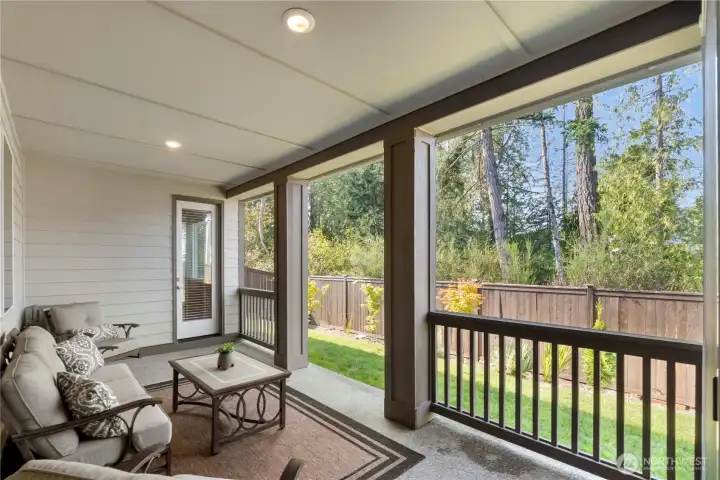 Extended covered patio with green belt view and private entrance to the primary suite