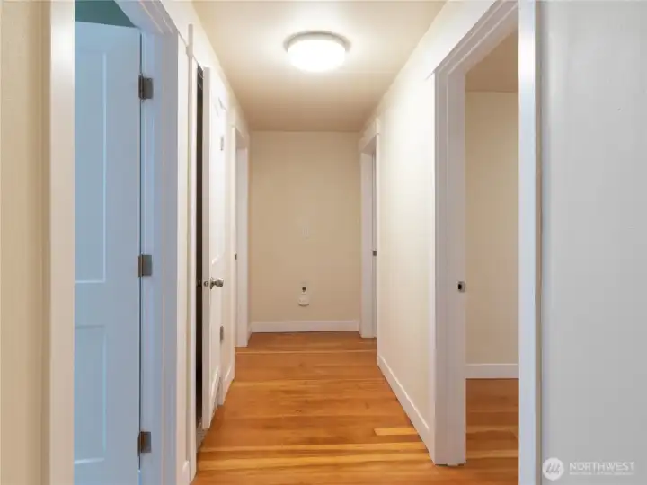 Classic douglas fir flooring throughout second story. Full guest bath is the first door on your left, both bedroom 1 and 2 are on your right, middle door leads to the third level with the flex room and last door on your left is the primary bedroom with bath en suite!