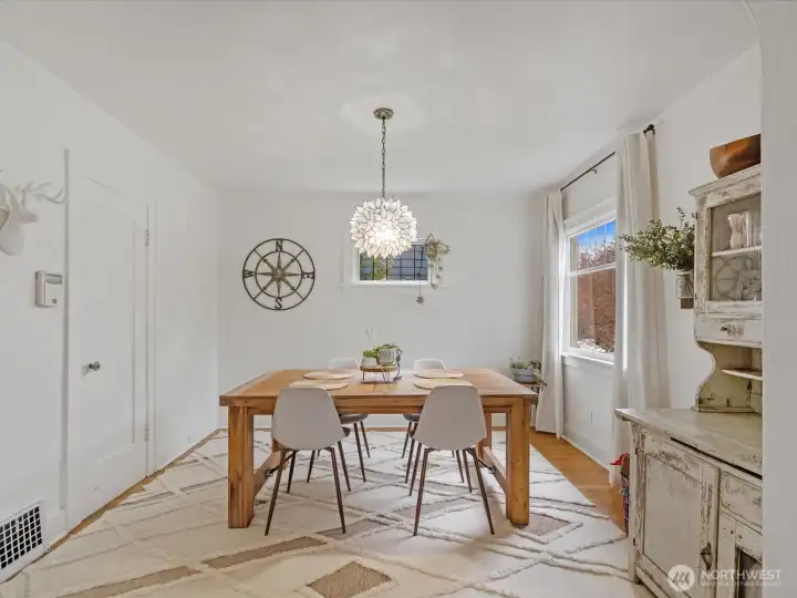 The dining area features space for a large table beneath a striking chandelier