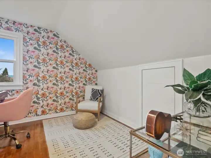 A charming sloped ceiling with floral wallpaper, adding a touch of whimsy