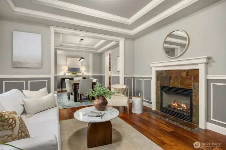 Living room with fireplace focal point, wainscoting detail, and open transition to the dining room.