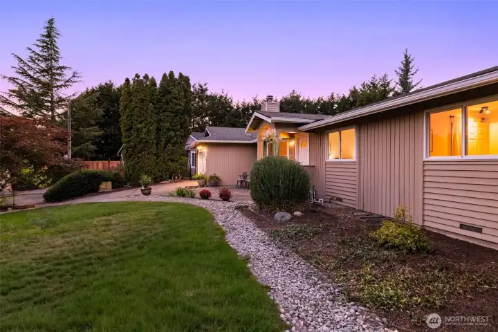 Exterior view with stone pathway and mature landscaping.