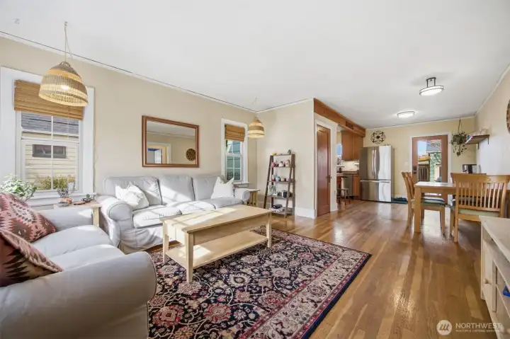 Looking toward the dining room and kitchen from the listing room with the door leading to the basement in between.