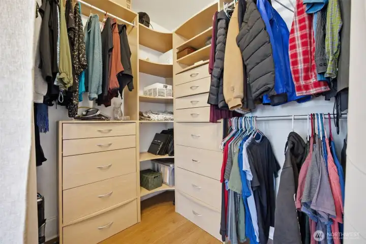 A close-up view of the primary walk-in closet which has built-in storage and hanging space.