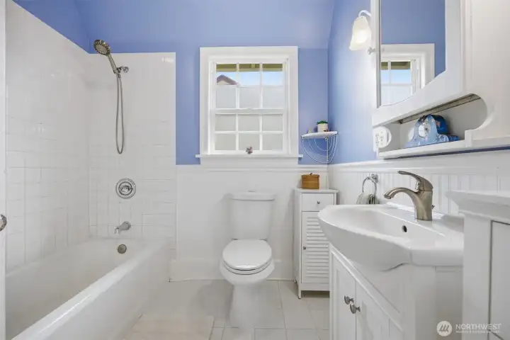 The full bath is nicely done in white tile and bath fixtures and finishes.