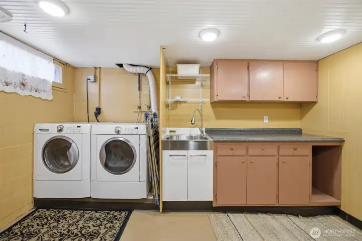 The laundry room is conveniently located in the basement and has quite a bit of cabinet storage and counter space.