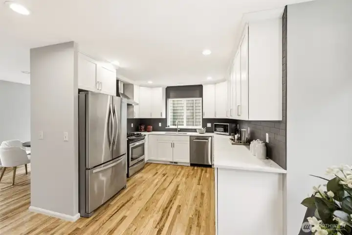 Renovated kitchen with stainless appliances and quartz countertops.