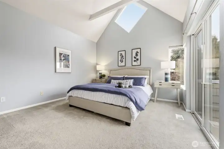 Primary bedroom on upper floor boasting soaring ceilings and plenty of space.