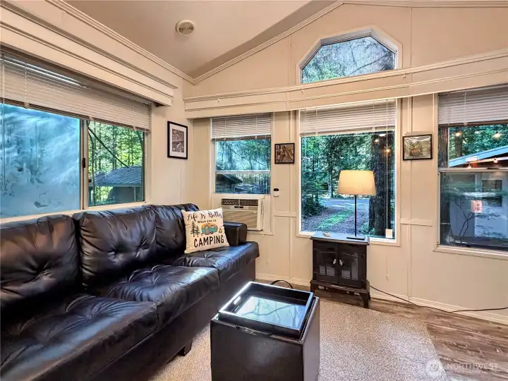 The couch is a queen size hide-a-bed, while the coffee table converts into an ottoman with a smaller ottoman tucked inside. Window A/C with smart updates and an electric fireplace makes this space ready for all seasons!