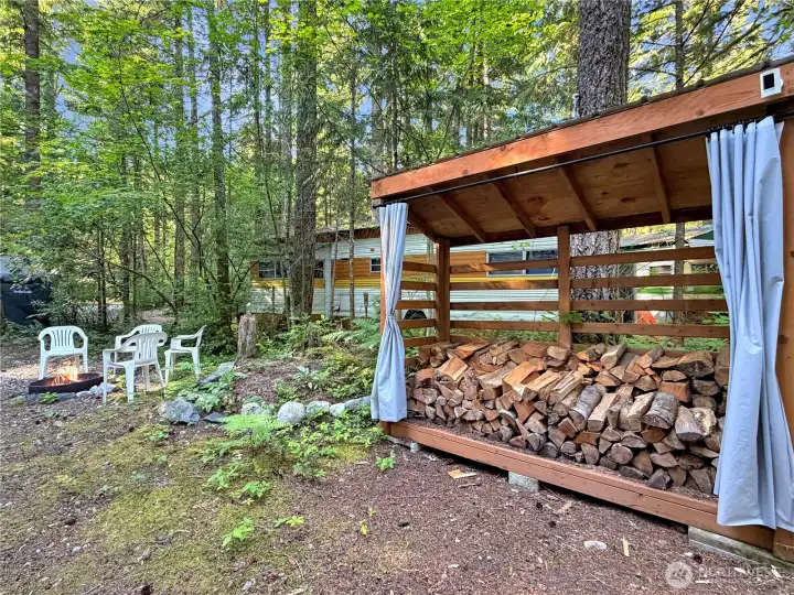 Wood shed plastic curtains can be closed to protect wood from the elements.