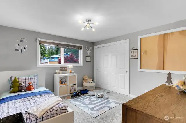 The first bedroom is spacious and offers a full size closet with additional storage and modern lighting. Note the newer vinyl windows found throughout the home.