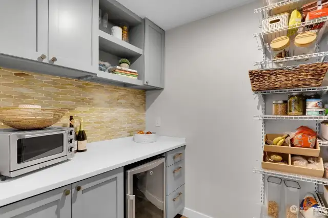 Everyone wants a pantry like this one! Cabinets, tile backsplash, quartz counter, mini beverage fridge and loads of storage for those Costco purchases.