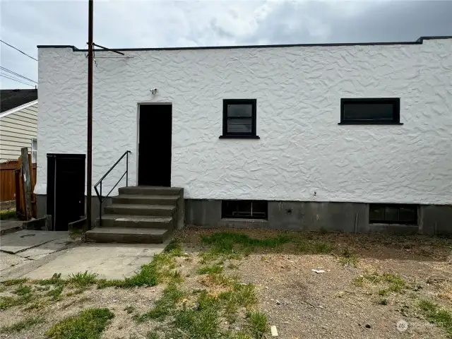 View of the back of house; basement entry can be seen