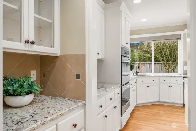 Convenient Butler's pantry with glass upper cabinets and granite counter make it easy to entertain.