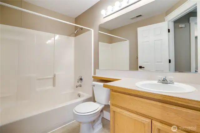 This clean and tidy bathroom boasts updated millwork throughout and a fresh coat of paint. Notice the new hardware on the door.