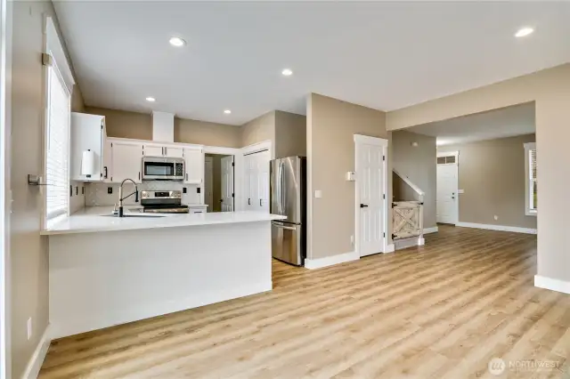 This beautifully refreshed kitchen boasts new countertops, an elegant tile backsplash, and freshly painted cabinets that brighten the space. Complete with brand-new stainless appliances and updated hardware, it's fully updated and ready for you to enjoy culinary creativity. The door to the right of the refrigerator provides additional storage underneath the stairway.
