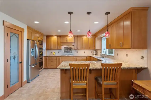 kitchen with granite counters, double oven, 5-burner stove & bar seating