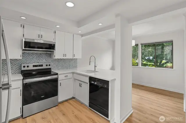 Refreshed kitchen. New sinks, faucets, quartz countertops, backsplash, range & refrigerator