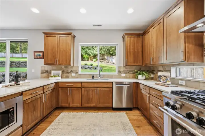 Entering the kitchen from the garage.  Stainless appliances and beautiful cabinetry