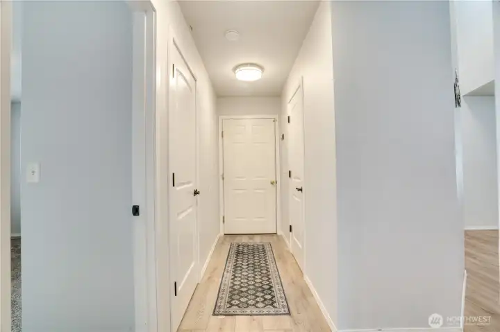 The hallway off the main floor bedroom leads to the half bath on the right, the garage in the center and a spacious storage/coat closet to the left. This home's storage is one of its most underrated features!!