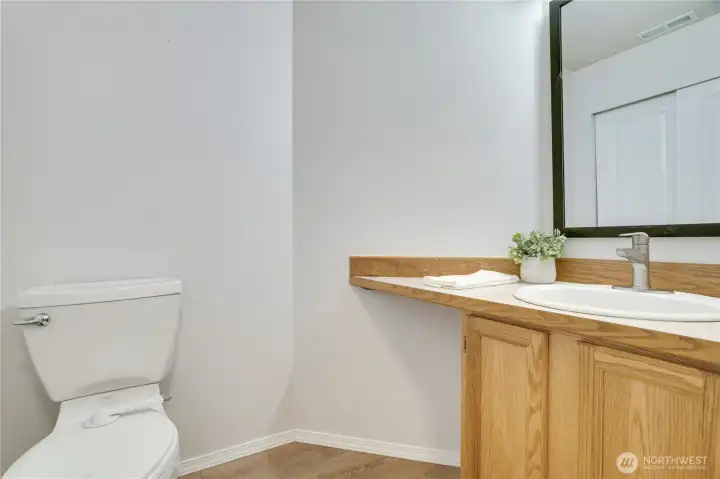 The main floor half bath has laminate floors and a newer mirror and light fixture