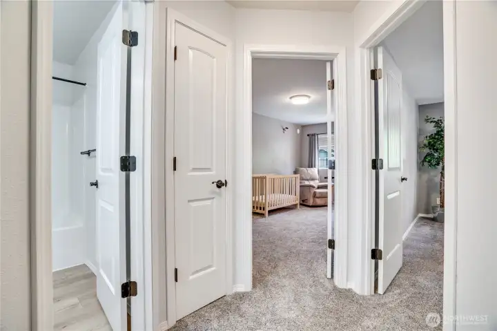 Down the hall is the second full bathroom, third and fourth bedrooms and another smaller linen closet amongst them all. Note the newer carpet and laminate floors here, too!