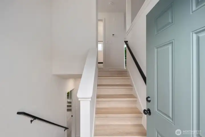 Bright entry with updated stairs, modern railing, and clean interior finishes.