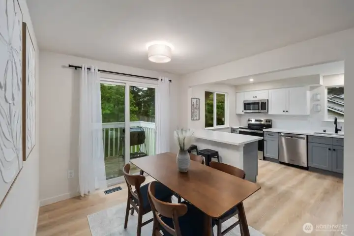 Updated kitchen with stainless appliances, breakfast bar, and dining area with deck access.