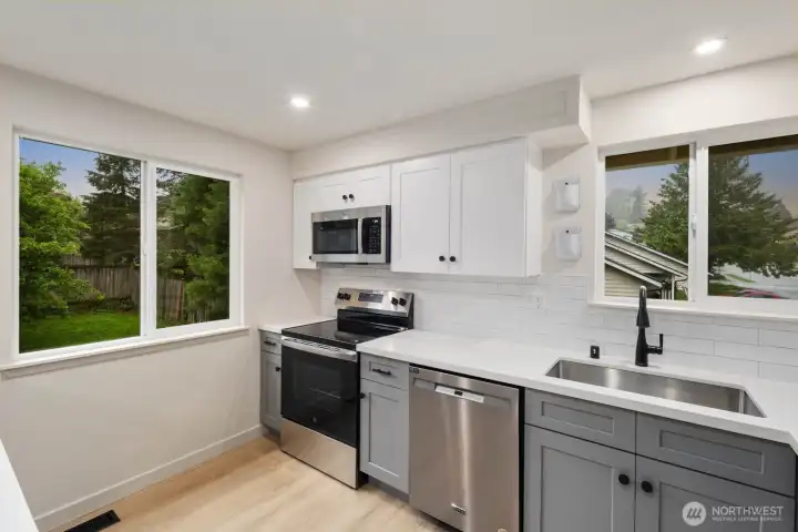 Updated kitchen with stainless appliances, subway tile backsplash, and modern cabinetry.