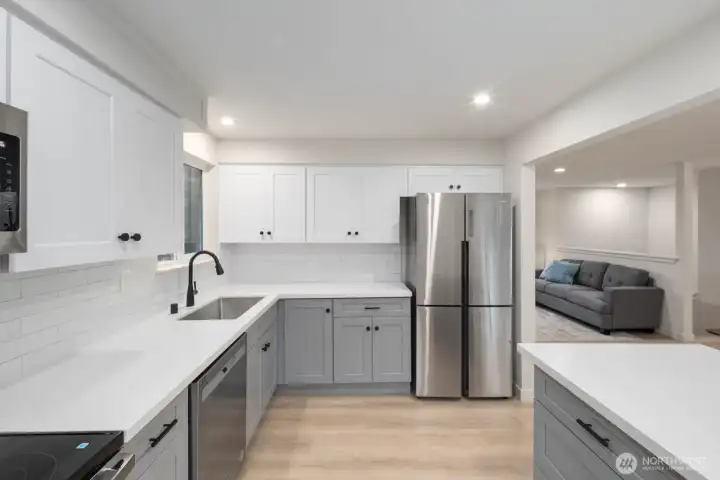 Open kitchen with modern cabinetry, stainless appliances, and seamless flow to living area.