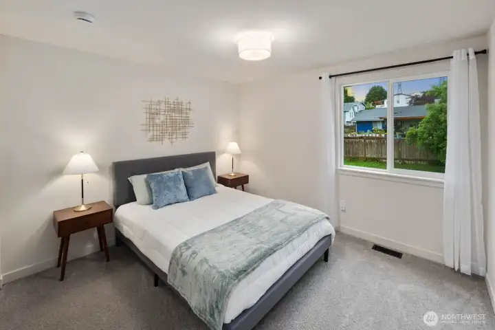 Comfortable bedroom with natural light, neutral finishes, and functional layout.
