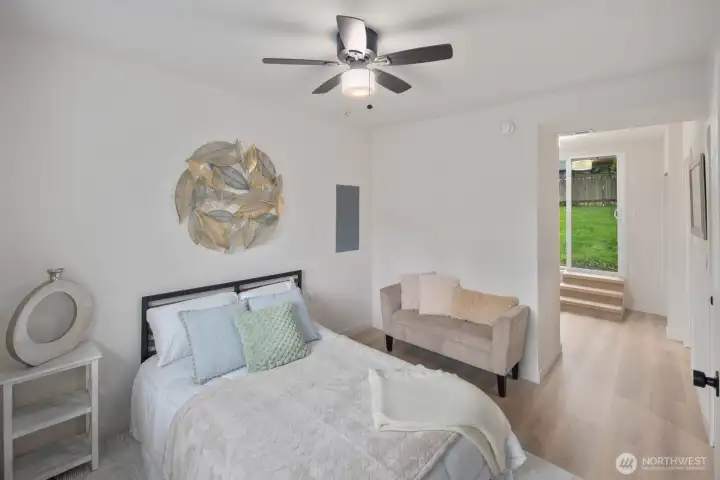 Private lower-level bedroom with en-suite bath, flexible space, and direct access to backyard.