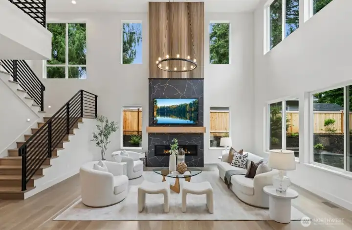 Memorable and dramatic statement two-story fireplace anchors this tremendous family room. It's warm, welcoming, and surrounded by walls of windows pulling in wonderful natural light.