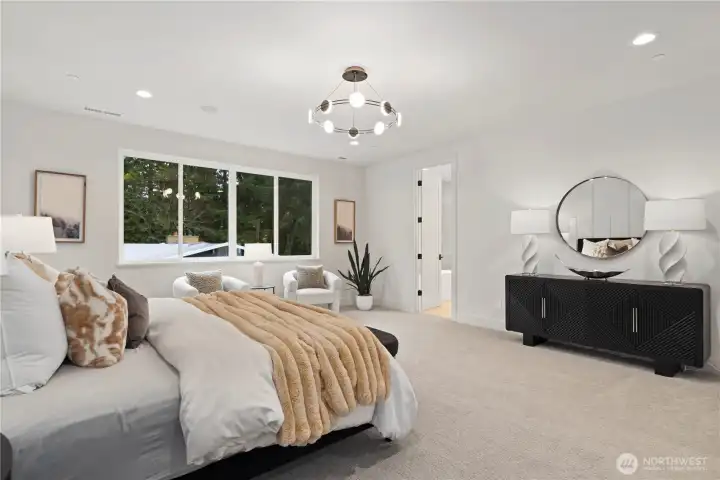 Spacious primary retreat with sitting area and tranquil outlook.