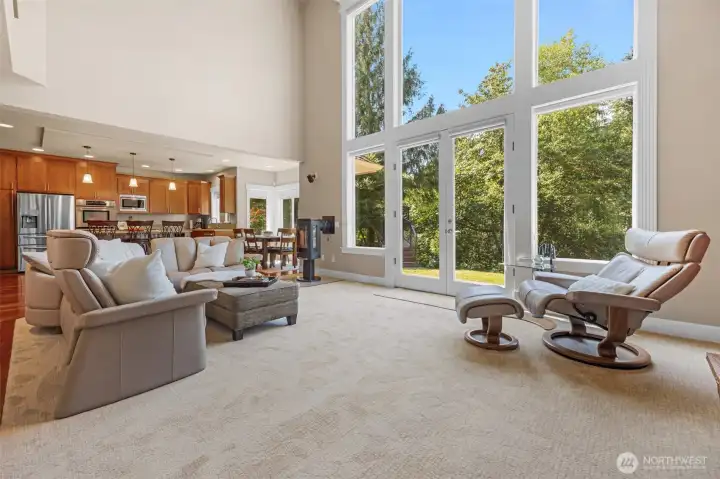 Living room framed by wall of windows that bring nature inside Living room framed by wall of windows that bring nature inside