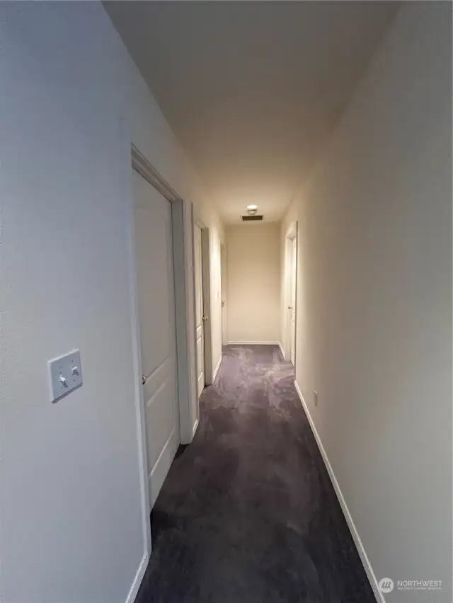 Hallway with 2 bedrooms and bath at left. Master BR at the end on the right.