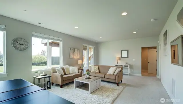 Downstairs recreation room with space for hanging out and to fit a ping-pong table.