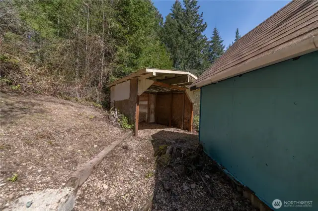 back yard view behind the shed and looking towards wood storage shed