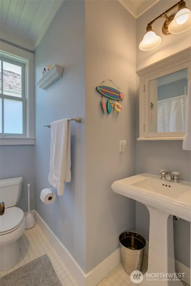 Cute vintage looking tile floor and pedestal sink with medicine cabinet add to the charm.