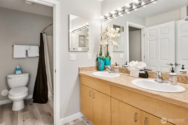 Primary bath with dual vanity sinks and step-in shower.