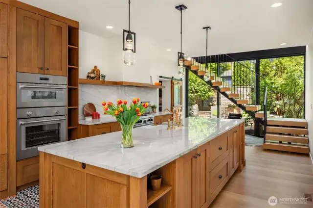 Custom quarter-sawn oak cabinetry pairs beautifully with quartzite countertops and artisan tile work.