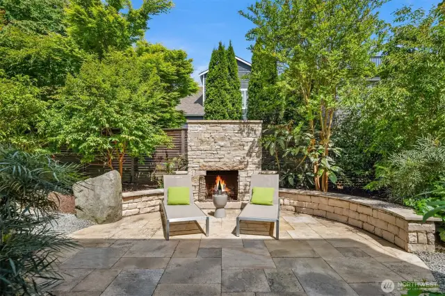 Outside, discover a serene bakyard oasis shaped by a limestone gas fireplace for alfresco gatherings in a warm, inviting ambiance.