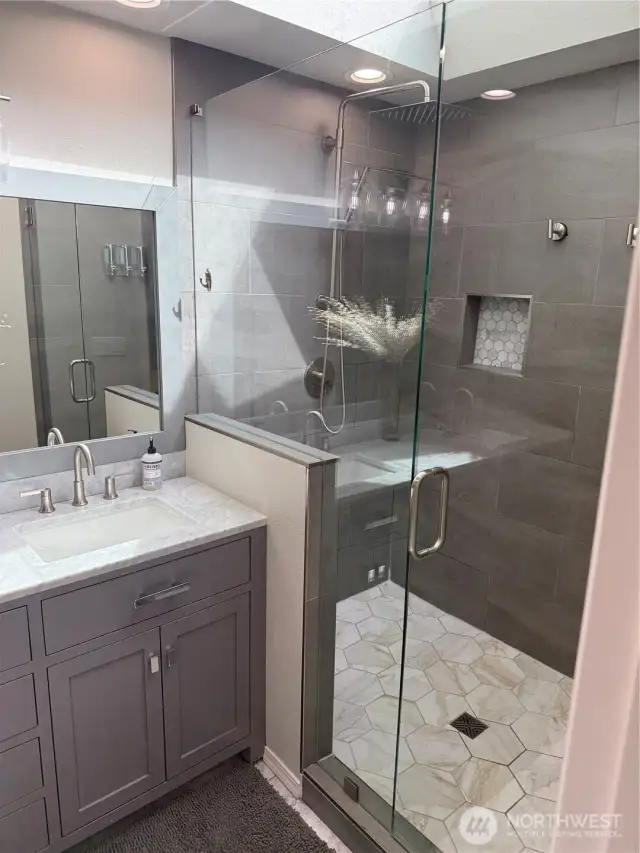 Primary bath with large tiled walk-in shower and skylight