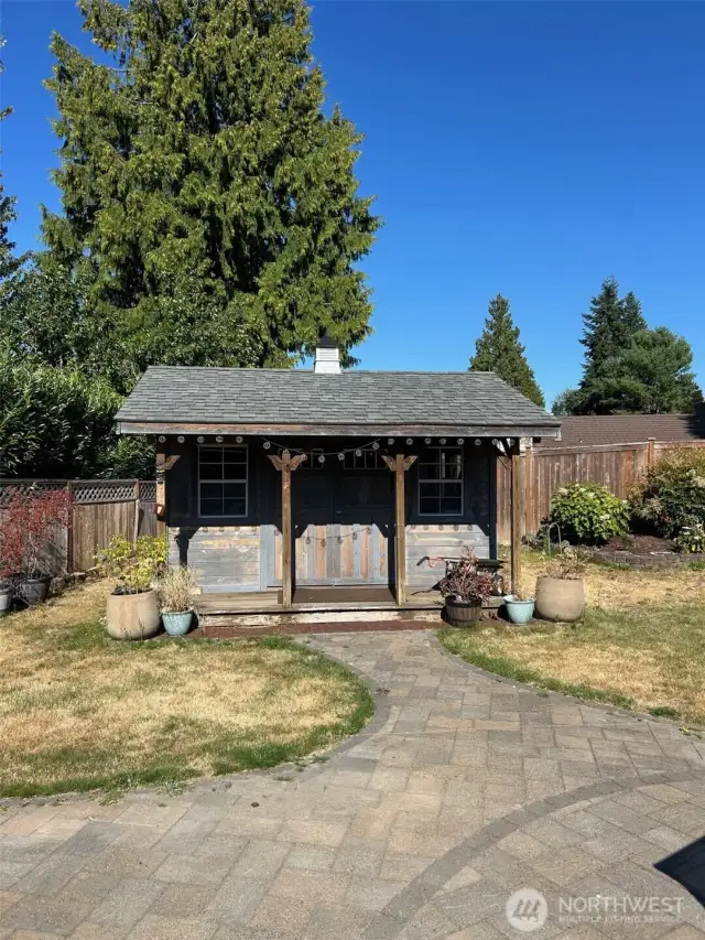 ?? Versatile Backyard Studio  This well-maintained garden shed features vintage-style double doors, charming windows, and a brick paver entry framed by potted plants. Ideal as a creative workspace, storage solution, or private retreat—ready to adapt to your lifestyle.
