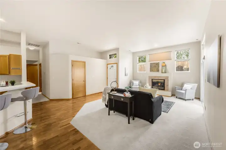 High ceilings and numerous windows create a bright, welcoming living space with a cozy gas fireplace.