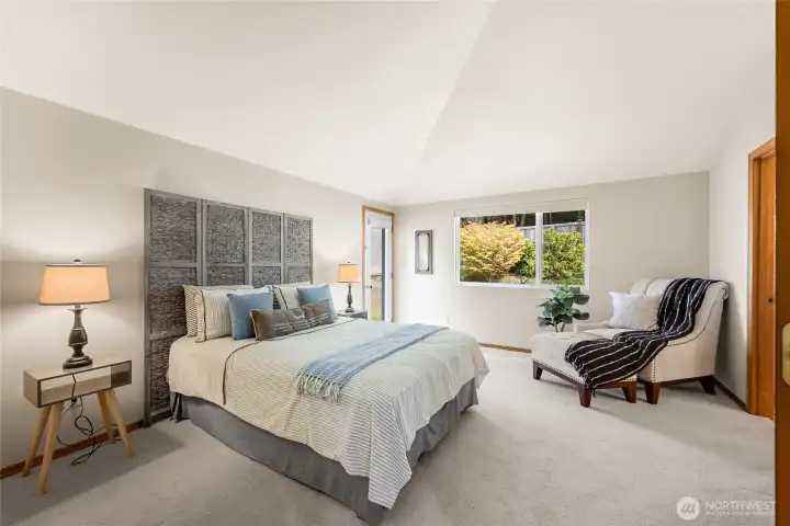Your dreamy retreat - an expansive primary bedroom with vaulted ceilings and patio access.