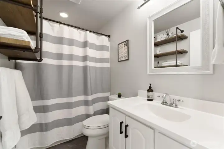 Main floor full bathroom with tub and shower enclosure.